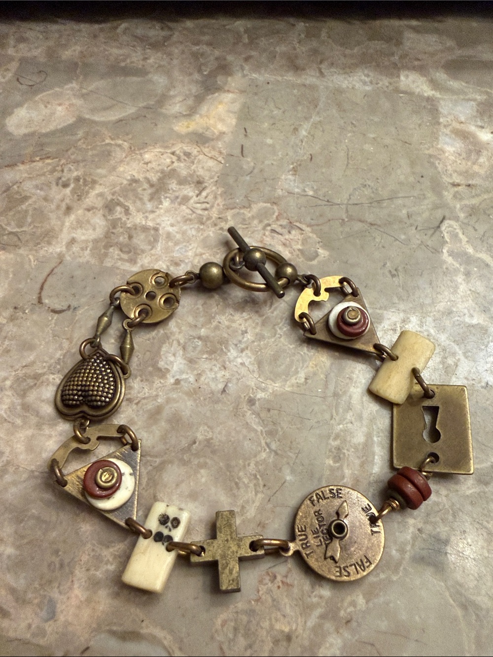 Artisan created mixed media gold tone and brass charm bracelet toggle closure